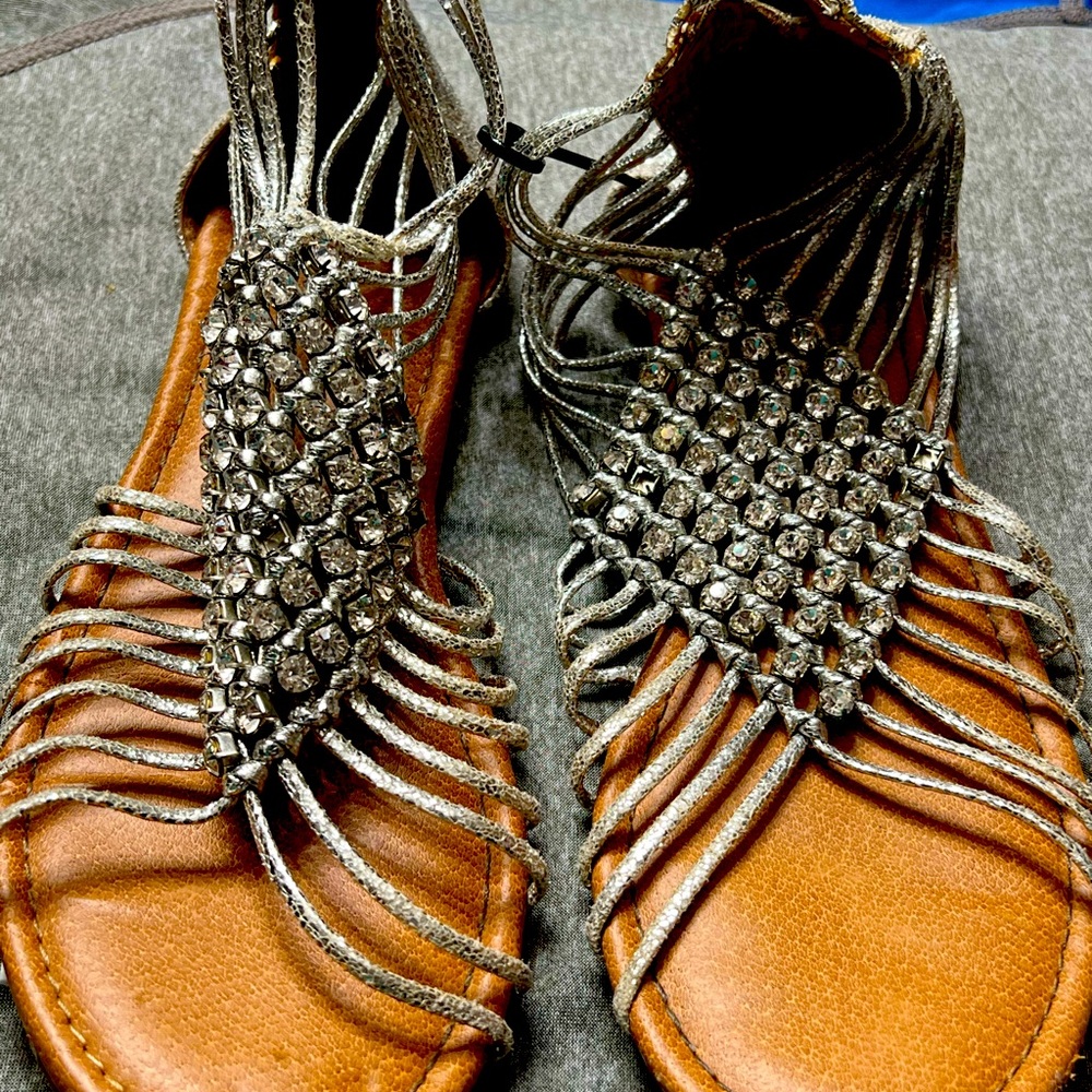 Used silver sandals with beading.  It does have marks on the toes of the shoes.